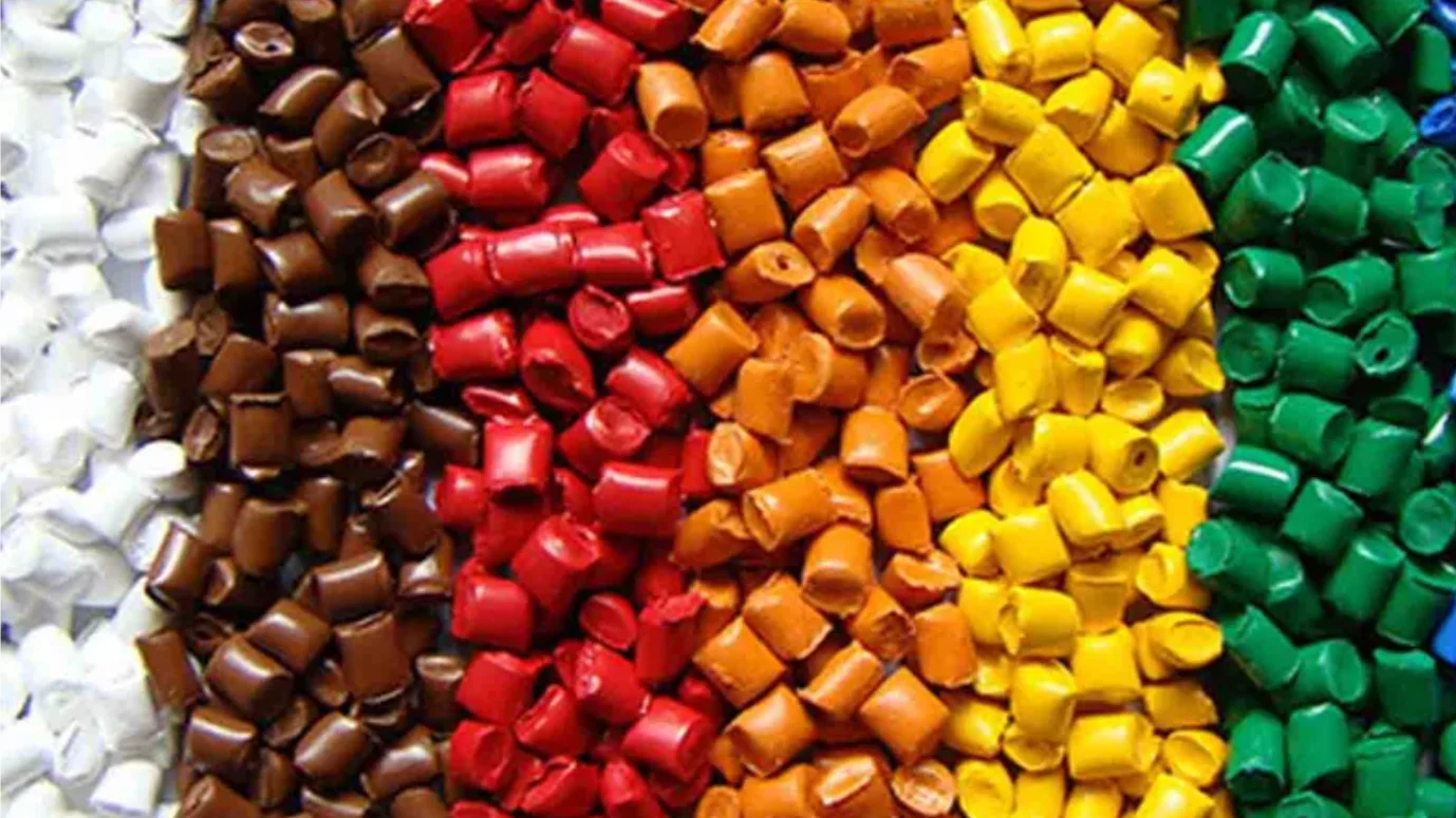 A technician examining plastic pellets used in injection molding.