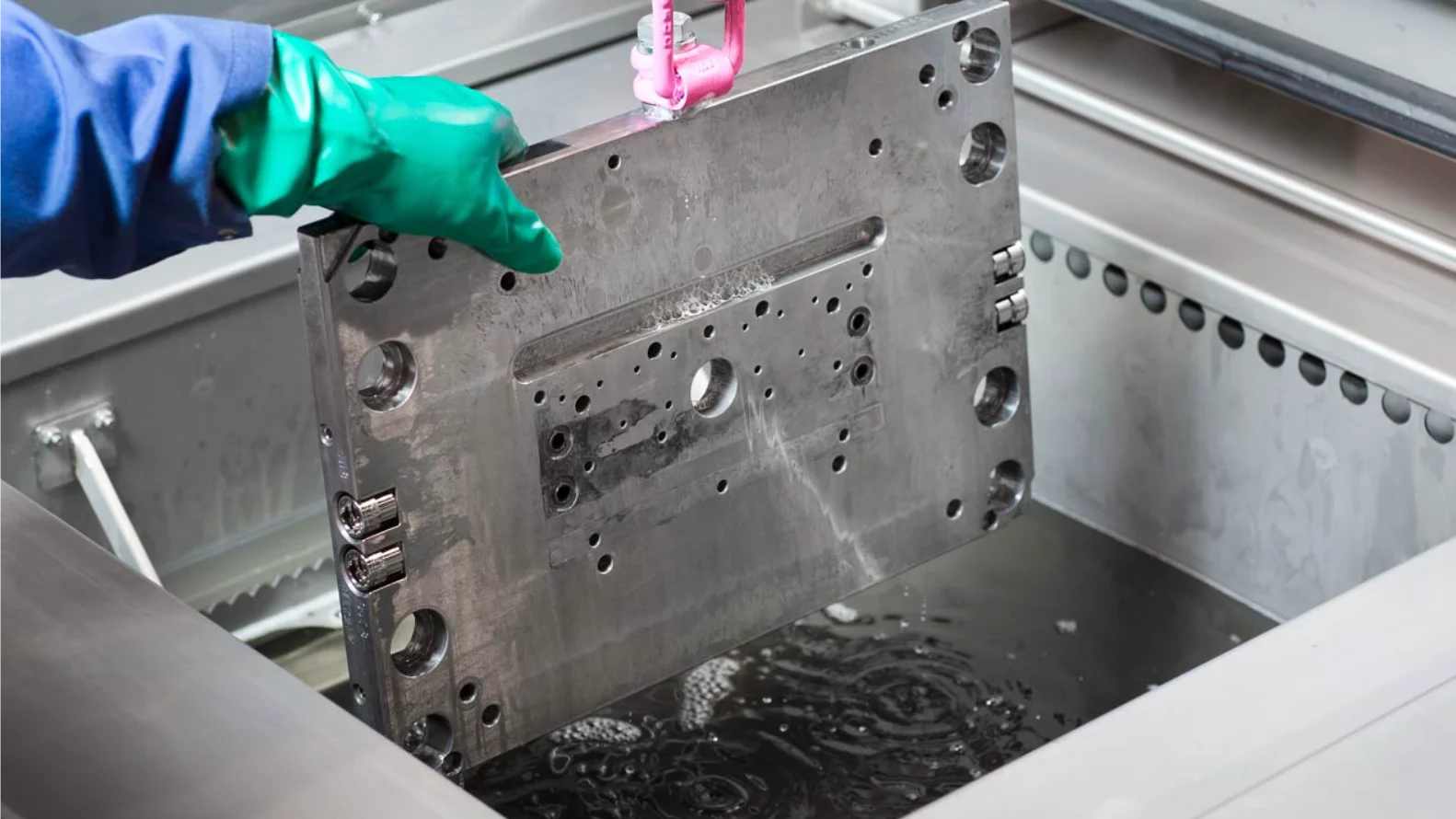 Ultrasonic cleaning process in action with intricate parts submerged in a tank